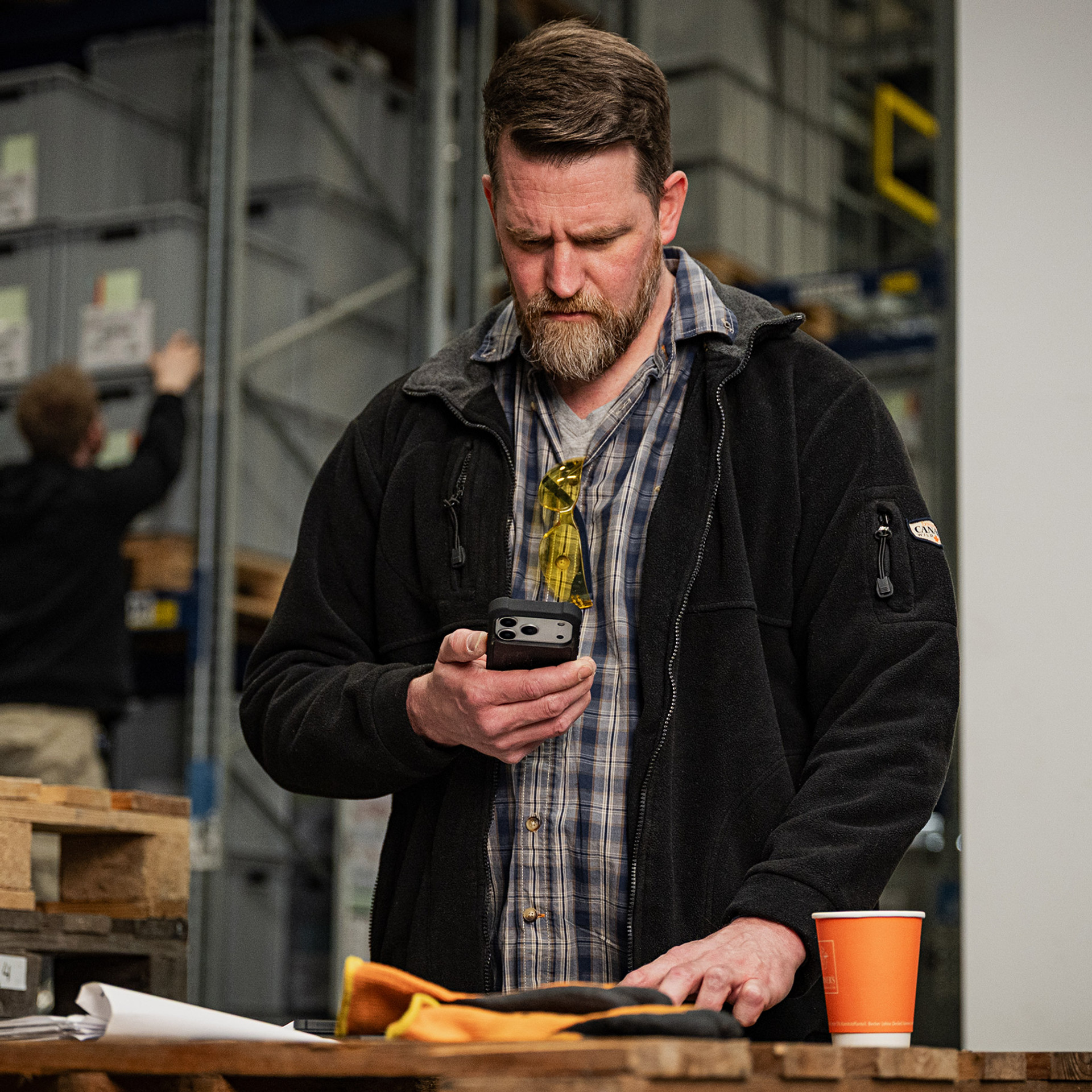 Baustellen-Leiter bei der Arbeit hält NIVOmax in der Hand.